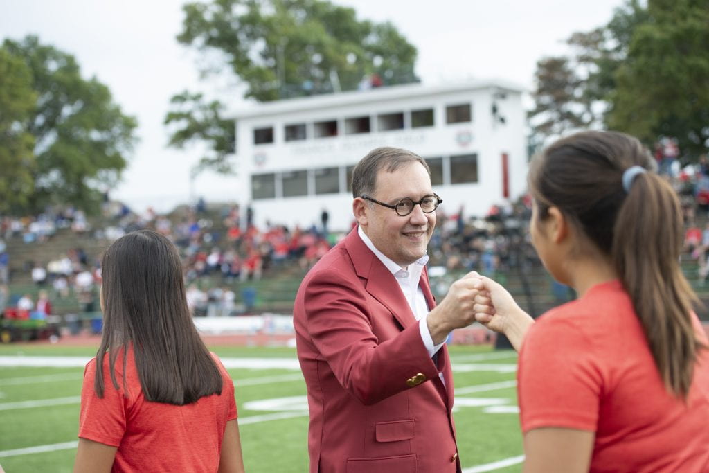 Chancellor Martin fist pumps a scholar-athletic on Francis Olympic Field