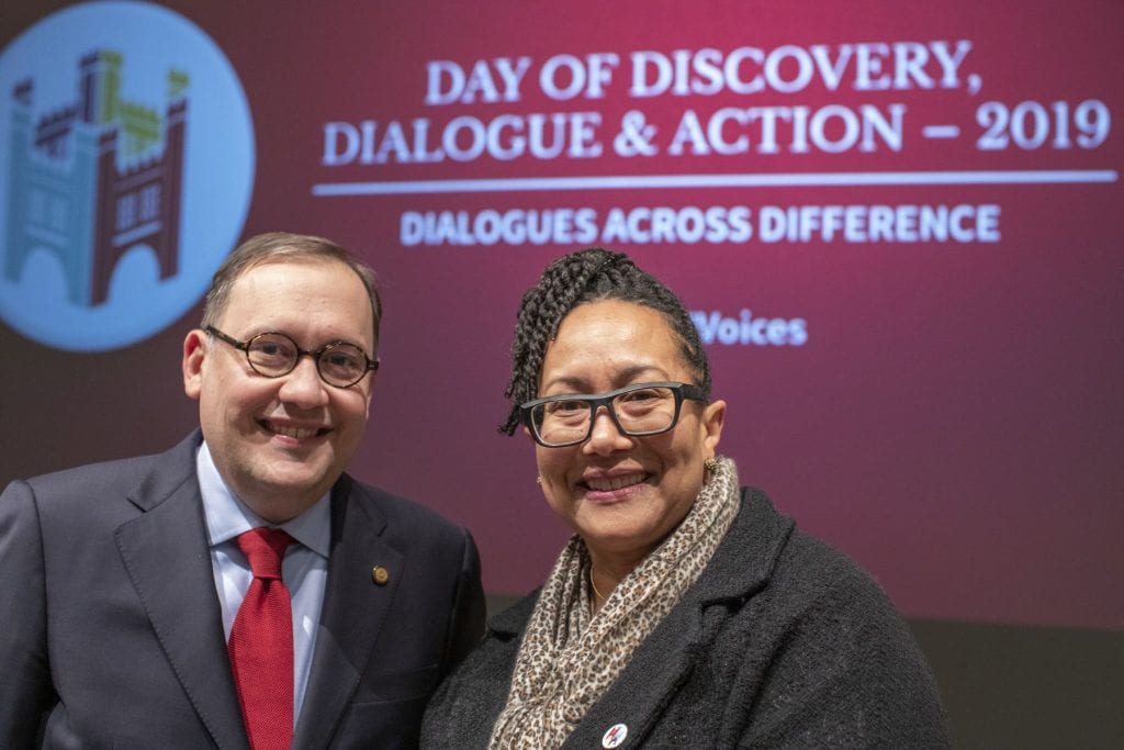 Andrew D. Martin and Adrienne Davis in front of sign reading "Day of Discovery, Dialogue & Action - 2019, Dialogues Across Difference"