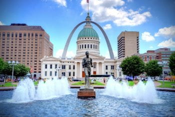 Runner statue with the old courthouse and Arch behind it